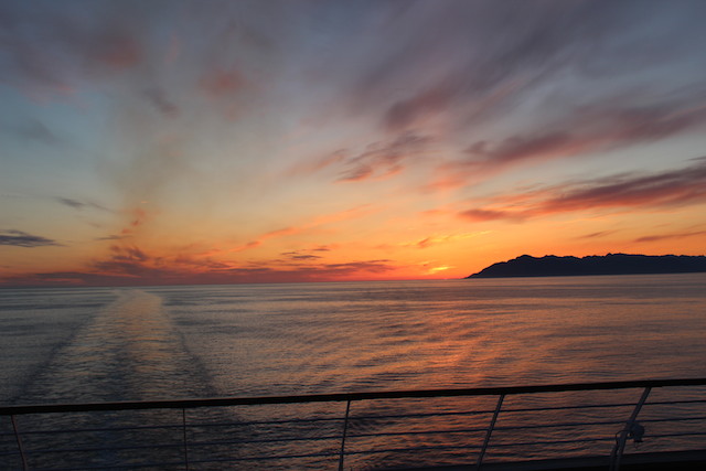 alaskan cruise travel holland america sunset off bow of boat